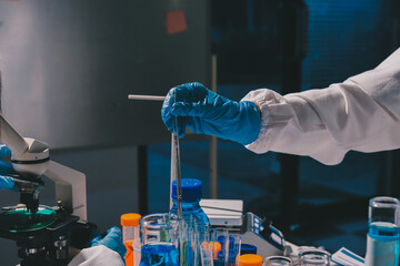 Scientist pipetting medical samples into microplate in laboratory