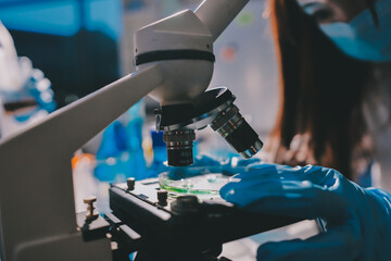 Scientist pipetting medical samples into microplate in laboratory