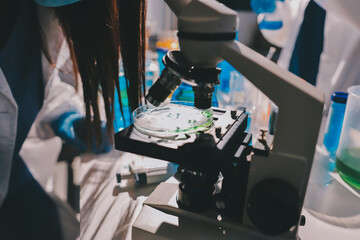 Scientist pipetting medical samples into microplate in laboratory