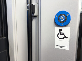 Blue accessibility call button with wheelchair symbol and maintenance staff call sign mounted on a...