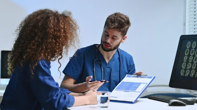 Medical expert discusses brain scan results with patient using tablet in modern clinic. Concept of neurology, diagnosis, healthtech
