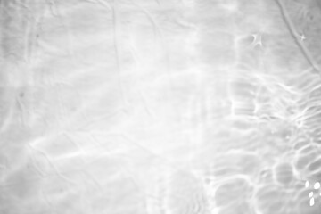 White water with ripples on the surface. Defocus blurred transparent white colored clear calm water surface texture with splashes and bubbles. Water waves with shining pattern texture background.