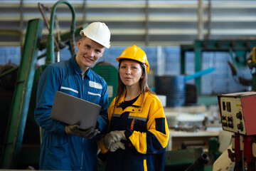 working woman : Caucasian mele and female manufacture technical or factory staff working with holding laptop computer standing at industry factory. Professional Mechanical Engineer
