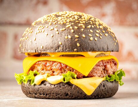 Fototapeta Burger z czarną bułką i niebieskim serem na tle cegły