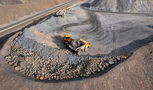 Industrial excavator loader of gold ore to truck, mining industry, Aerial top view