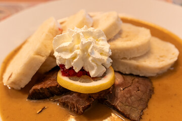 Traditional Czech Dish Svíčková with Dumplings, Cranberries, and Cream