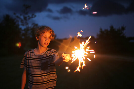Kid Playing with Sparkler Firework on Fourth of July in America - Powered by Adobe