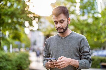 Portrait of a young man using his mobile phone in the city
