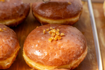 Closeup of a glazed donut with candied orange peel on top