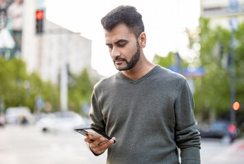 Portrait of a young man using his mobile phone in the city
