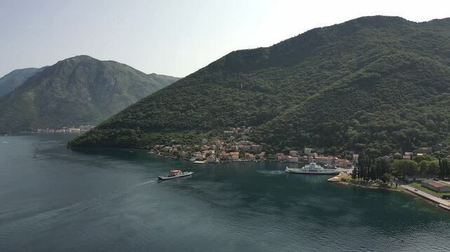 Aerial view of the ferry terminal in Lepetane, in a picturesque part of the Bay of Kotor in Montenegro, with mountains and summer scenery in the background.