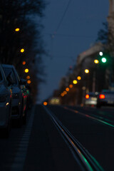 A nighttime view of a street with parked cars and illuminated traffic lights, capturing urban life and transport