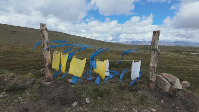 Colorful plastic bags tied on a rural fence along the Ausangate trekking trail in Peru, used by local herders to scare away animals.