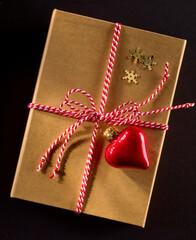 Geschenk mit rotweisser Schleife und rotem Herzanhaenger
