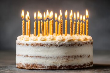 Birthday cake with many gold candles.  A round cake layered with light beige frosting, topped with small, delicate cream flower decorations.  Many gold-colored candles are lit, creating a warm, 