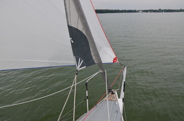 Sailboat bow and sail on calm lake