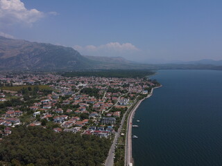 A serene aerial view of Lake Köyceğiz in Turkey on a calm summer day, showcasing tranquil blue waters, lush surroundings, and peaceful natural beauty.