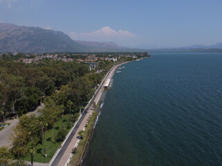 A serene aerial view of Lake Köyceğiz in Turkey on a calm summer day, showcasing tranquil blue waters, lush surroundings, and peaceful natural beauty.