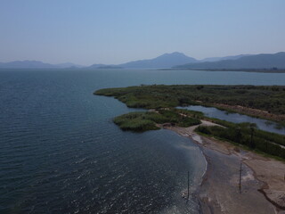 A serene aerial view of Lake Köyceğiz in Turkey on a calm summer day, showcasing tranquil blue waters, lush surroundings, and peaceful natural beauty.