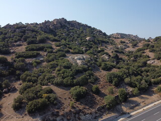 A drone view of South Türkiye's arid, Mediterranean-like hills with terra tones and sparse vegetation, captured during a scenic summer road trip