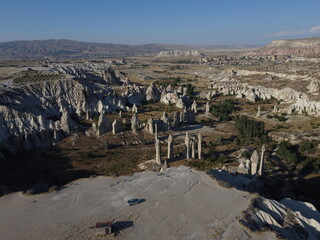 A stunning drone shot over Love Valley in Cappadocia, showcasing its iconic rock formations, surreal landscape, and warm tones under a clear sky.