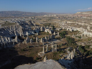 A stunning drone shot over Love Valley in Cappadocia, showcasing its iconic rock formations, surreal landscape, and warm tones under a clear sky.