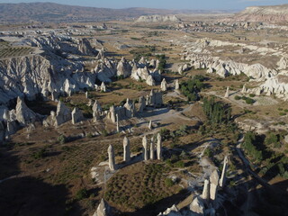 A stunning drone shot over Love Valley in Cappadocia, showcasing its iconic rock formations, surreal landscape, and warm tones under a clear sky.