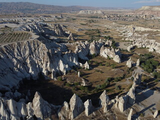 A stunning drone shot over Love Valley in Cappadocia, showcasing its iconic rock formations, surreal landscape, and warm tones under a clear sky.