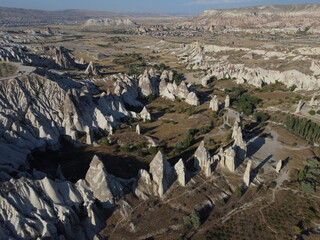 A stunning drone shot over Love Valley in Cappadocia, showcasing its iconic rock formations, surreal landscape, and warm tones under a clear sky.