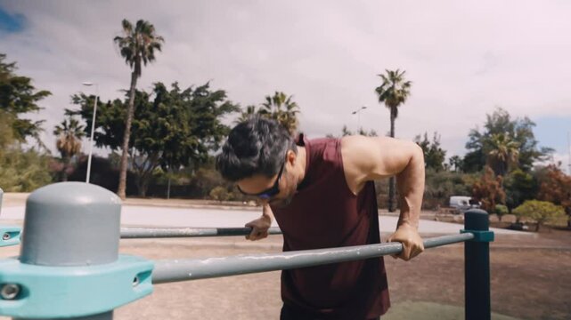 Fit Middle-Aged Man Doing Dips on Parallel Bars at Outdoor Calisthenics Gym