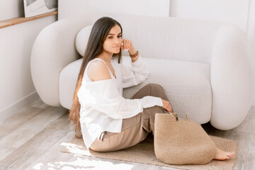 Elegant casual woman sitting and chilling with a stylish woven tote bag