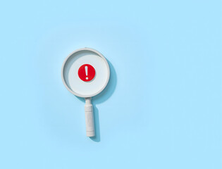 Magnifying Glass with Red Exclamation Mark on Blue Background