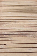 Wooden decking on the beach, close-up on the boards. Boardwalk. Background. Weathered wooden boards...