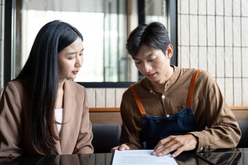 Entrepreneurial Meeting. Two professionals discussing business plans at a modern cafe.