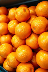 A high-resolution stock photo of piled oranges on a supermarket shelf displays iridescent colors and reflections, commercial-grade quality, professional aesthetic