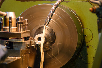 The lathe machine finish cut metal shaft parts with liquid coolant method.