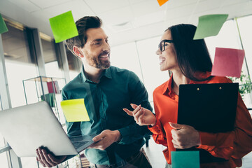Colleagues Collaborating in a Modern Office Environment Surrounded by Colorful Notes and Engaging...