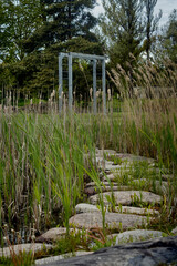 Stone road through tall grass with arch