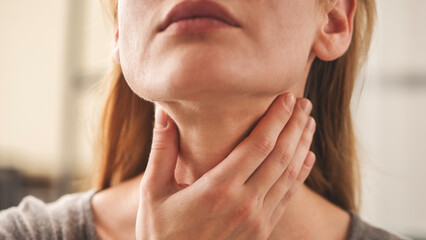 Young woman pulping her inflamed neck