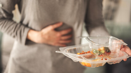 Woman with bloating and stomach pain after fast food meal