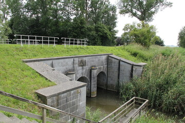 a historic sea lock in the dutch countryside in zeeland for draining the polder