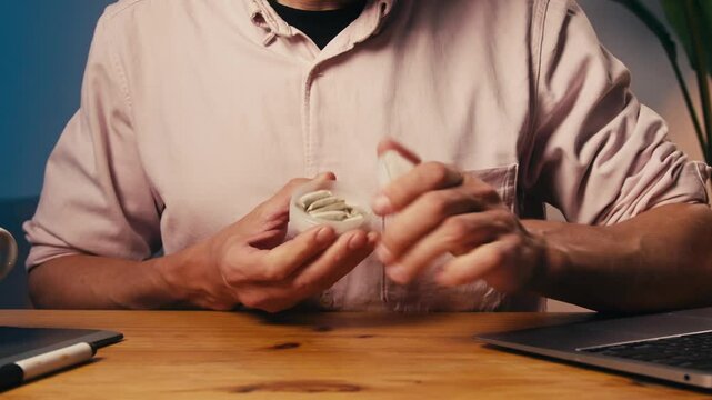 Snus nicotine tobacco close up, pack of tobacco for gum. unhealthy addiction. Man opening box with snus and taking one. 