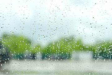 Raindrops on a window creating a blurry view of the outdoors