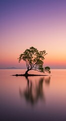 Lone tree standing in tranquil lake landscape