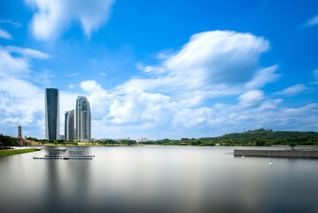 Modern skyline of Putrajaya, Malaysia with tall towers and calm lake under dramatic blue sky and...