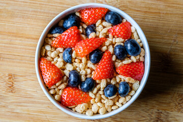 Bowl Of Classic Rice Krispies Breakfast Cereals With Fresh Strawberries And Blueberries