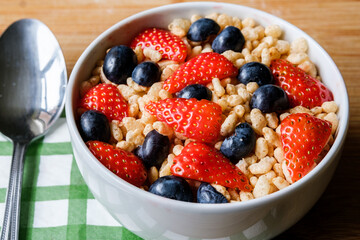 Bowl Of Classic Rice Krispies Breakfast Cereals With Fresh Strawberries And Blueberries