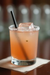 Cocktail Refreshment: A crystal glass showcasing a vibrant cocktail, complete with a straw and ice cube, resting on a soft coaster. The beverage offers a visual treat.