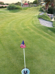 Obraz premium Golf Course Putting Green With Flag and Well-Manicured Landscape Details