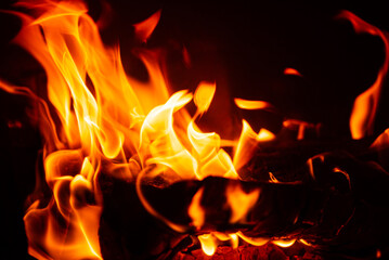 Bright flames dance chaotically, illuminating the darkness with warm hues
